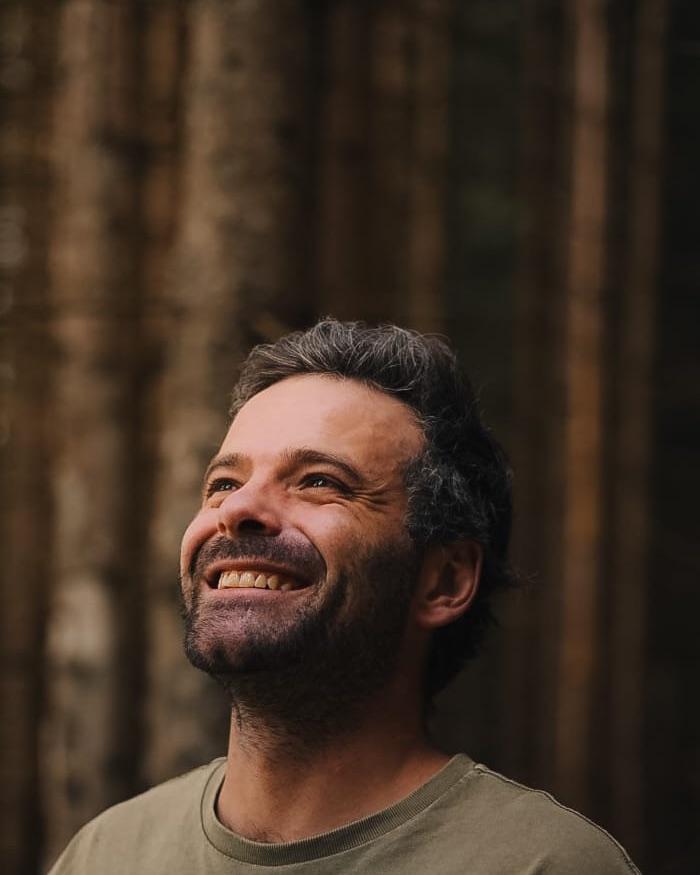 Mathieu Dupont-Vieux, dans un sous-bois de conifères, le regard levé.